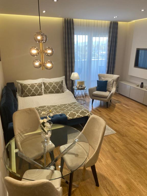 sala de estar con cama, mesa y sillas en Tiffany Lux Apartment, en Trebinje