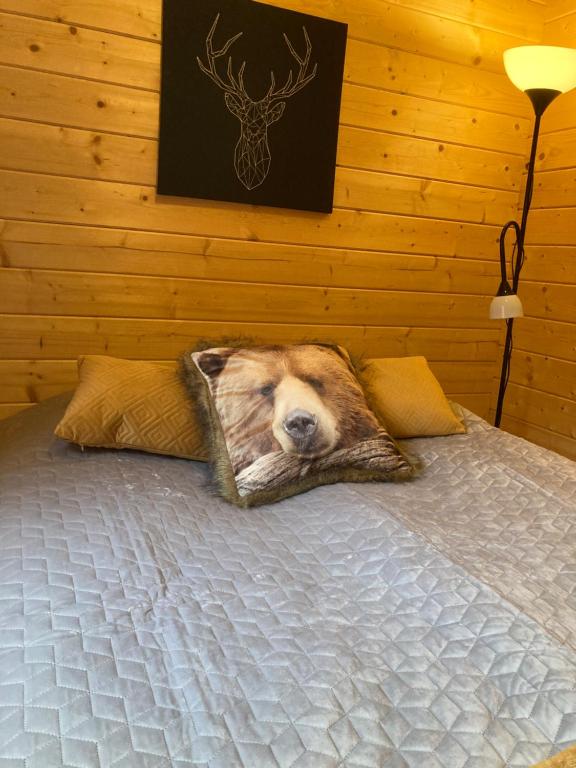 a bedroom with a bed with a largeanimal head on it at Asplunda Gård, Kolmården stuga nr 2 in Kolmården