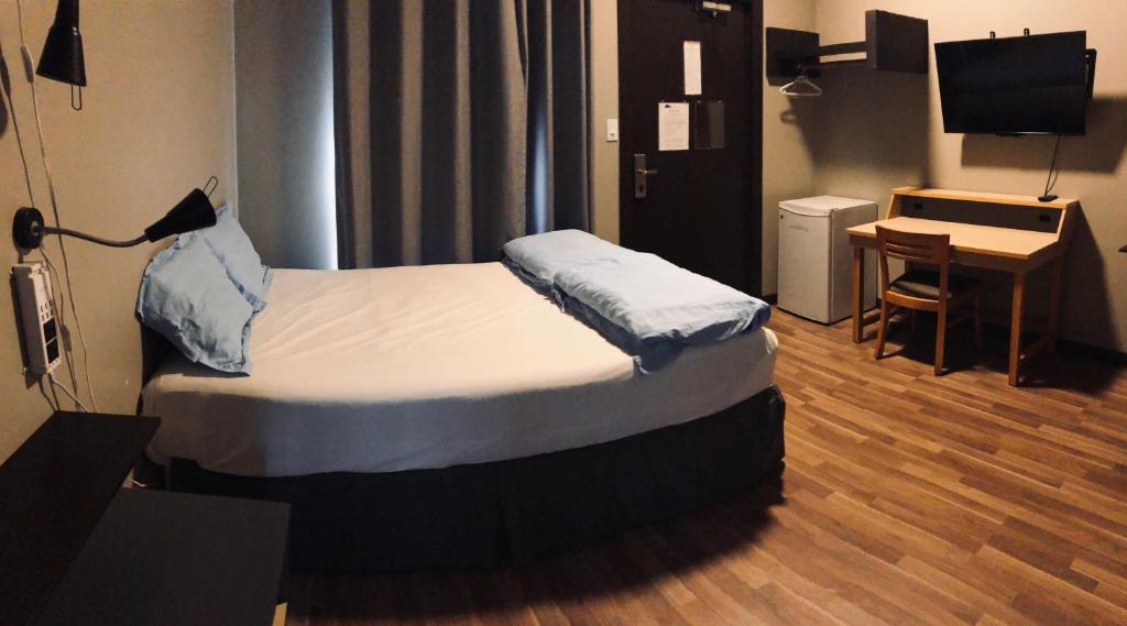 a small room with a bed and a desk at Banff International Hostel in Banff