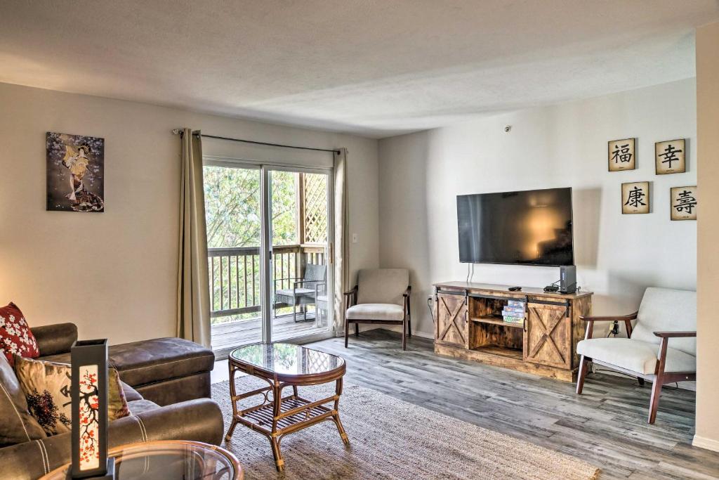een woonkamer met een bank en een flatscreen-tv bij Centrally Located Brandon Condo with Pool Access in Branson