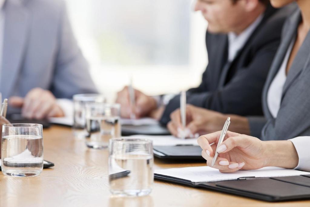a group of people sitting at a table writing on a document at Crowne Plaza Bahrain by IHG in Manama