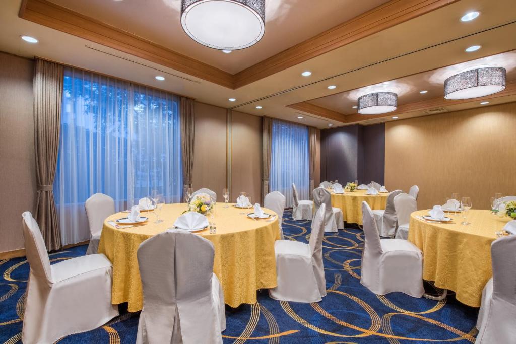 a conference room with round tables and white chairs at ANA Crowne Plaza Kanazawa by IHG in Kanazawa