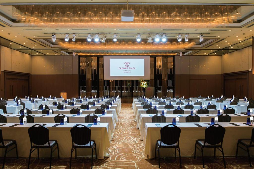 a conference room with tables and chairs and a screen at ANA Crowne Plaza Kanazawa by IHG in Kanazawa