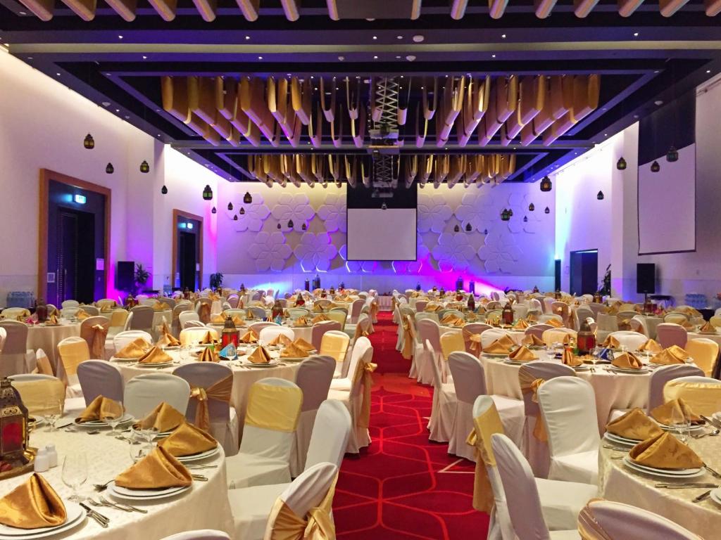 a large banquet hall with white tables and chairs at Crowne Plaza Yas Island by IHG in Abu Dhabi