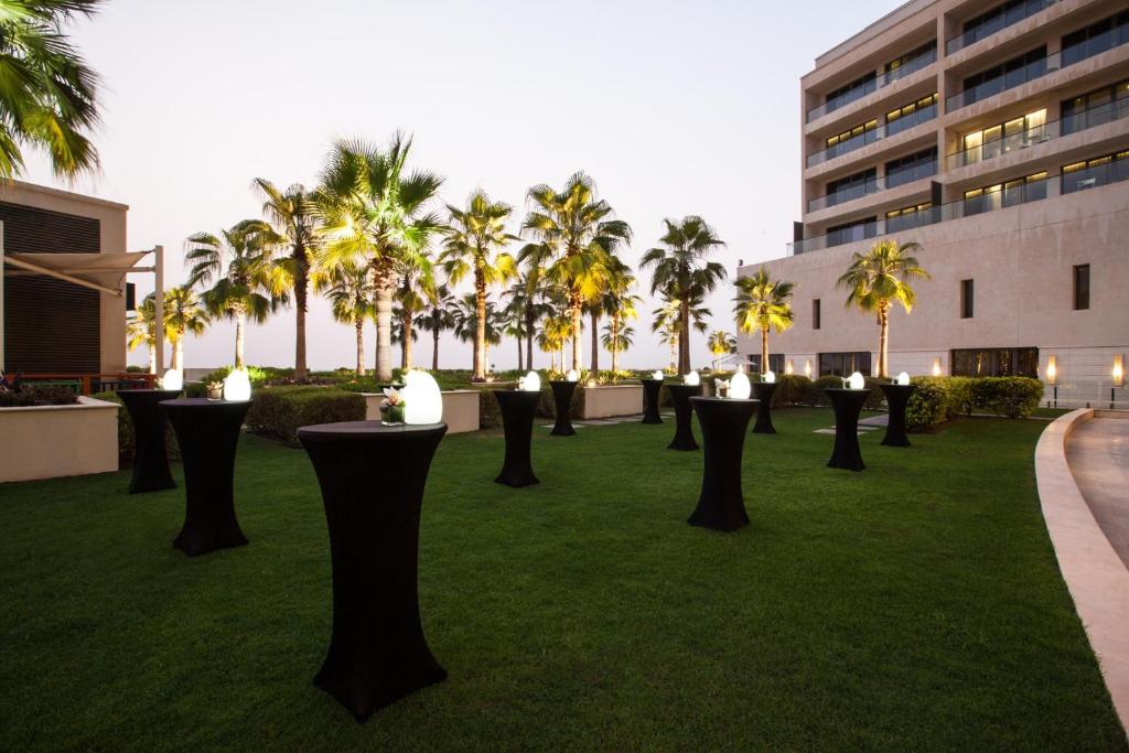 a field of grass with palm trees and a building at Crowne Plaza Yas Island by IHG in Abu Dhabi