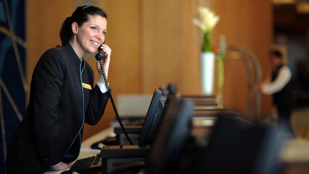 a woman talking on a phone in front of a computer at Crowne Plaza Yas Island by IHG in Abu Dhabi