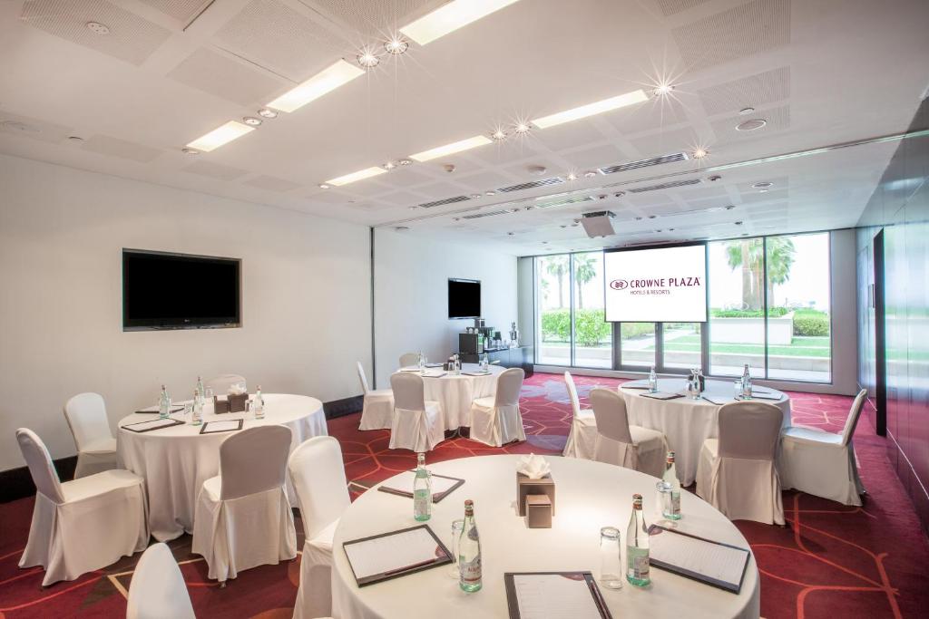 a conference room with white tables and chairs and a screen at Crowne Plaza Yas Island by IHG in Abu Dhabi