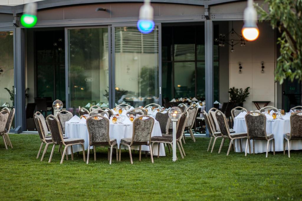 a group of tables and chairs on the grass at Crowne Plaza Istanbul Oryapark by IHG in Istanbul
