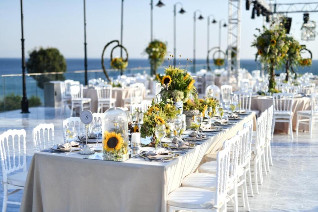 a long table with white chairs and tables with flowers at Crowne Plaza Florya Istanbul by IHG in Istanbul
