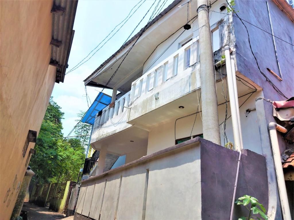 - un bâtiment avec un balcon sur le côté dans l'établissement Guesthouse Maura, à Pondokcina