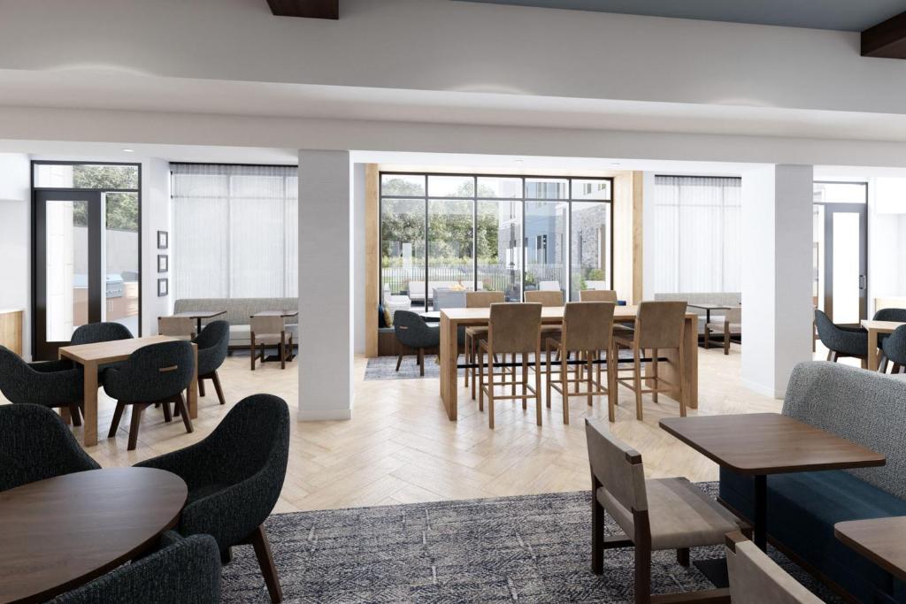 una sala da pranzo con tavoli, sedie e finestre di Staybridge Suites - Ames, an IHG Hotel ad Ames