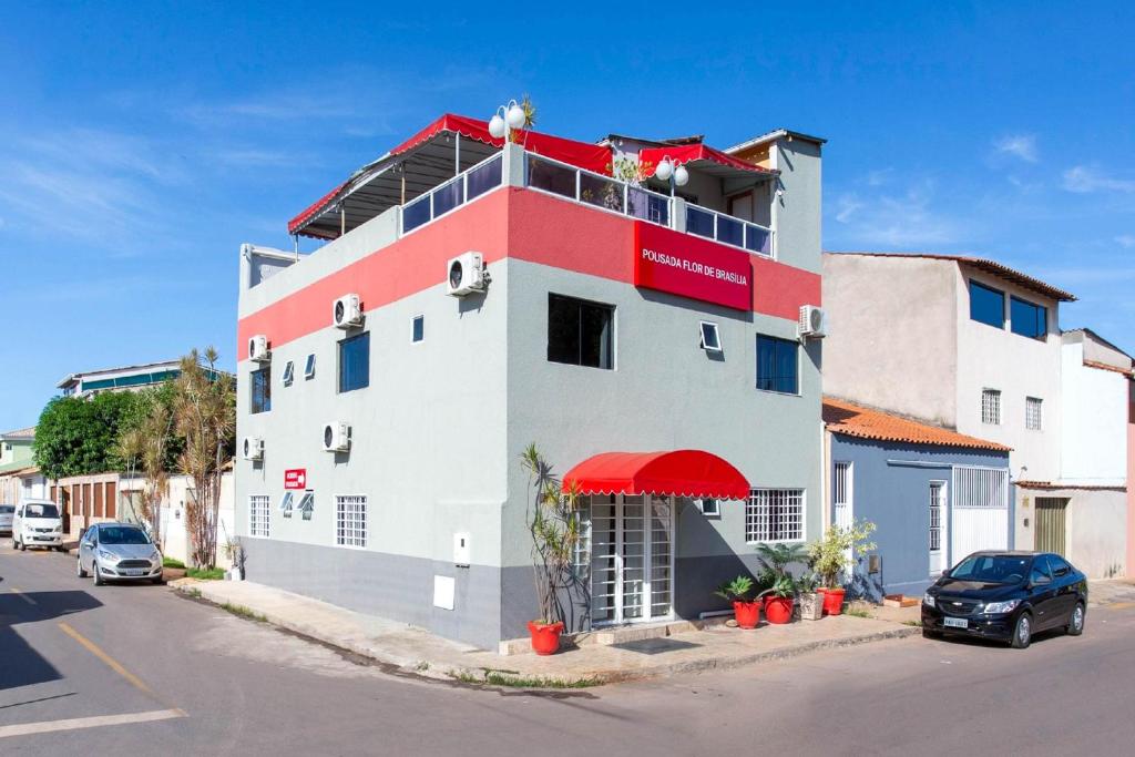 un edificio rojo y blanco al lado de una calle en Pousada Flor De Brasília, en Brasilia