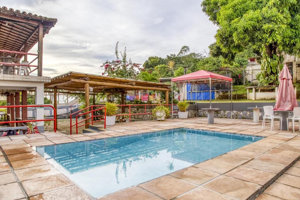 una piscina en un patio con un pabellón en OYO Praia Hotel Recanto do Tomé - Salvador, en Paripe
