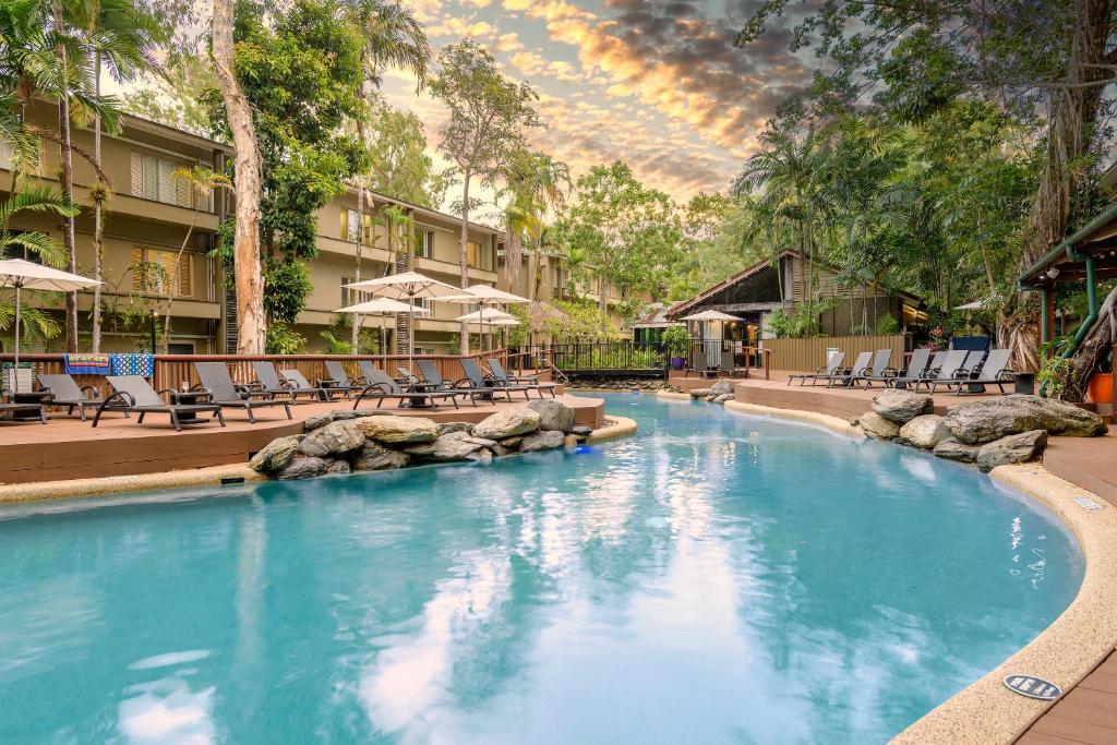 a large swimming pool with chairs and a resort at Ramada Resort by Wyndham Port Douglas in Port Douglas