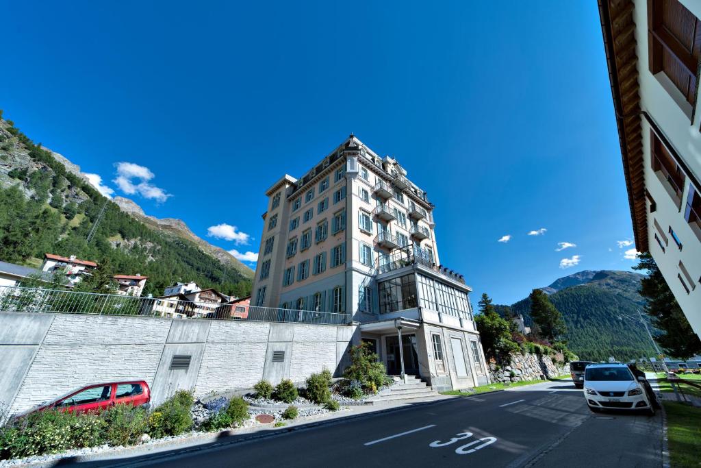 a building with cars parked on the side of a street at Chesa Roseg - Pontresina in Pontresina