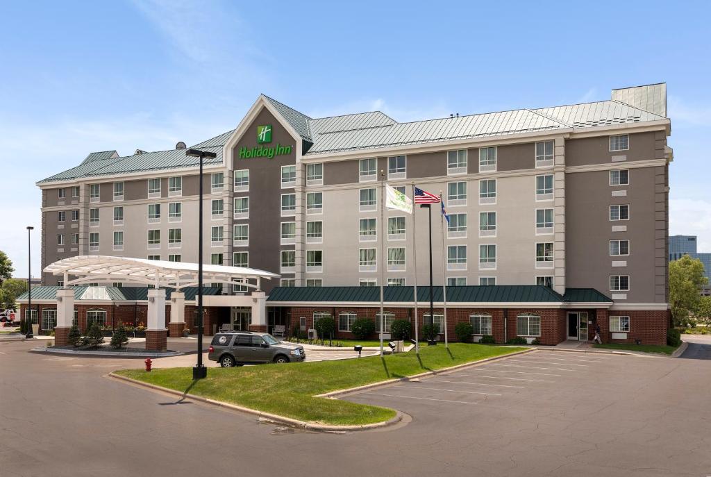 a hotel with a car parked in a parking lot at Holiday Inn - Bloomington W MSP Airport Area, an IHG Hotel in Bloomington