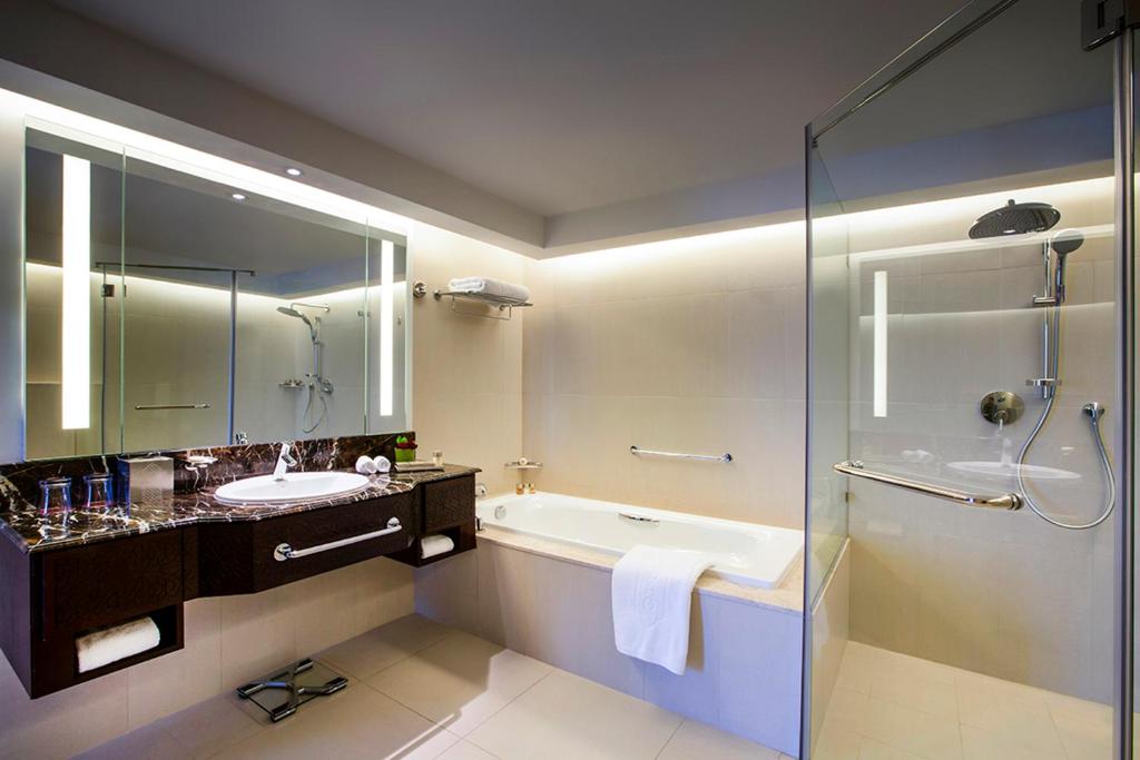 a bathroom with a tub and a sink and a shower at Bab Al Qasr Residence in Abu Dhabi