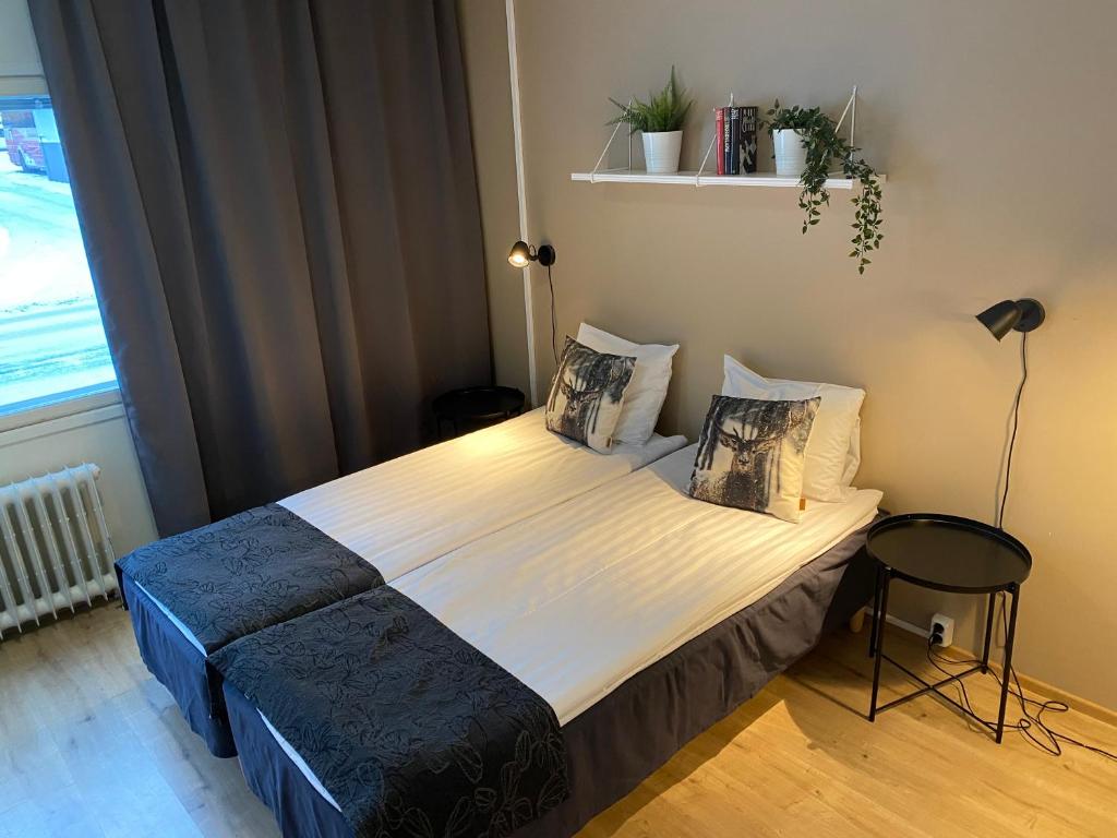 um quarto com uma cama num quarto com uma janela em Hotel Aakenus Apartments em Rovaniemi