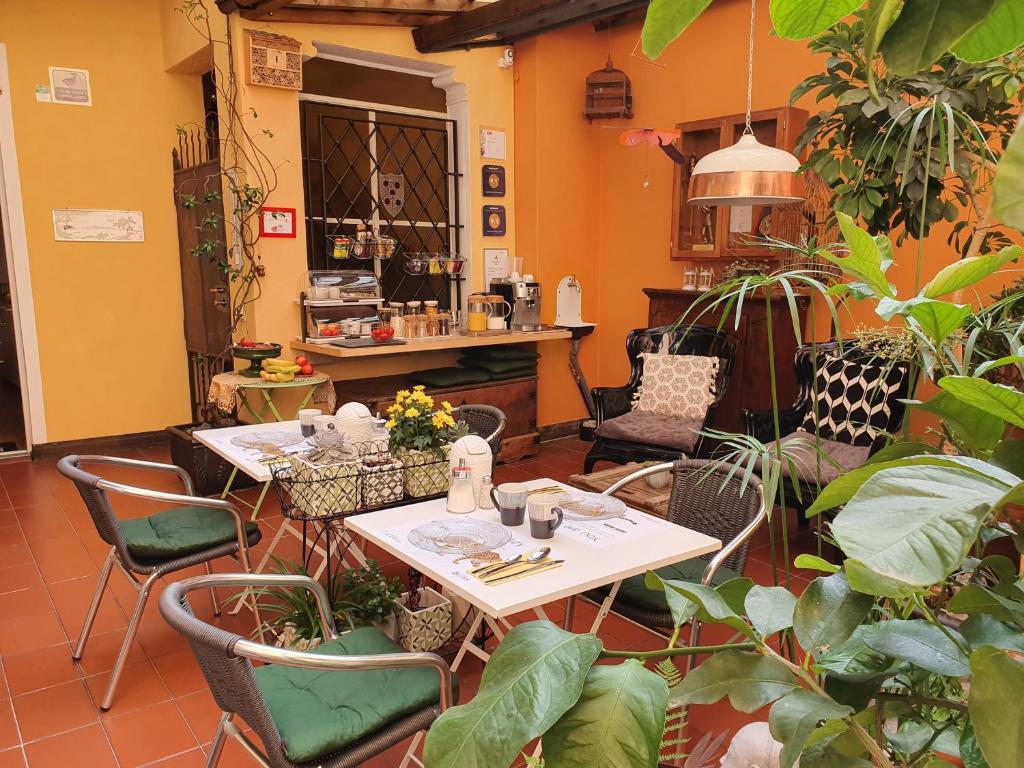 um restaurante com duas mesas, cadeiras e plantas em Garni Giacometti em Locarno