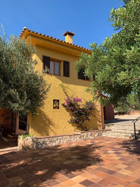 a yellow house with trees in front of it at Casa Mola in Perelló