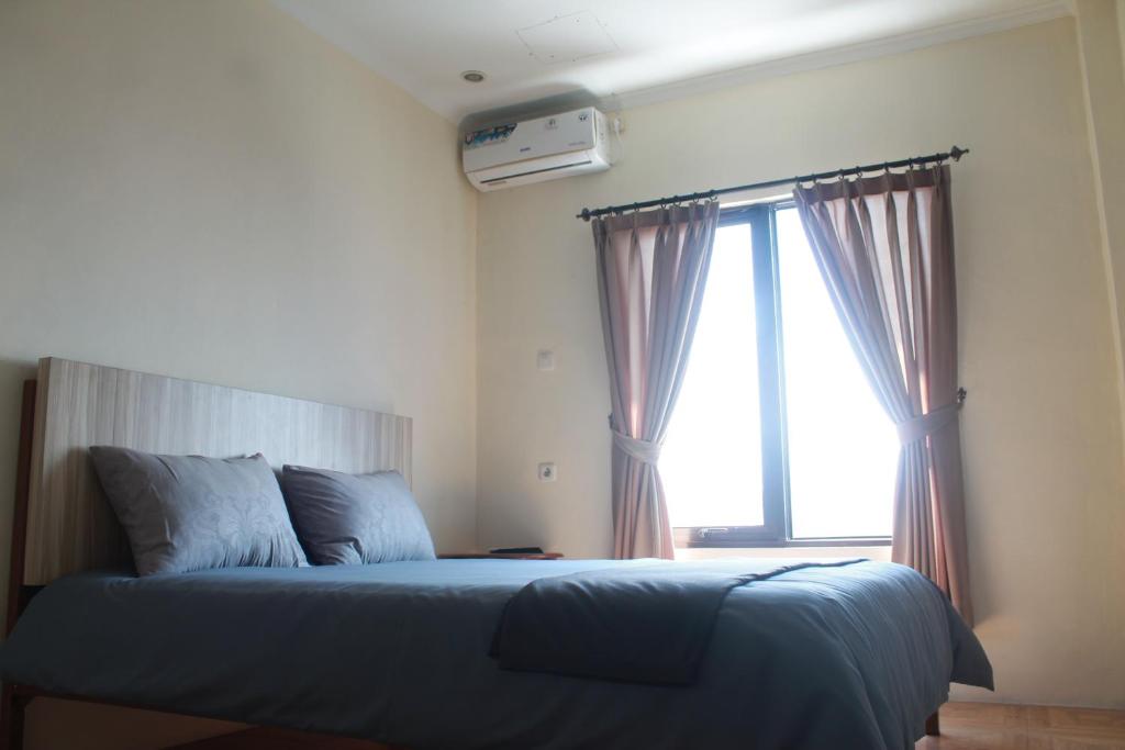 a bedroom with a blue bed with a window at bumimakhraja syariah 4 in Bandung