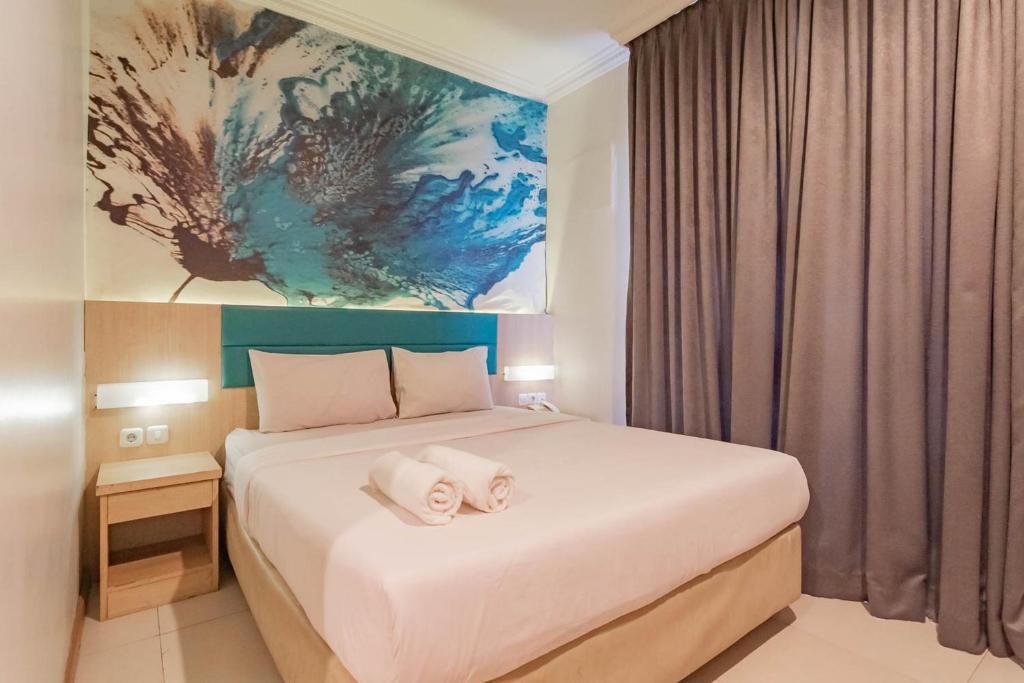 1 dormitorio con 1 cama con 2 toallas en RedDoorz At Hotel Arimbi Dewi Sartika Baru, en Bandung