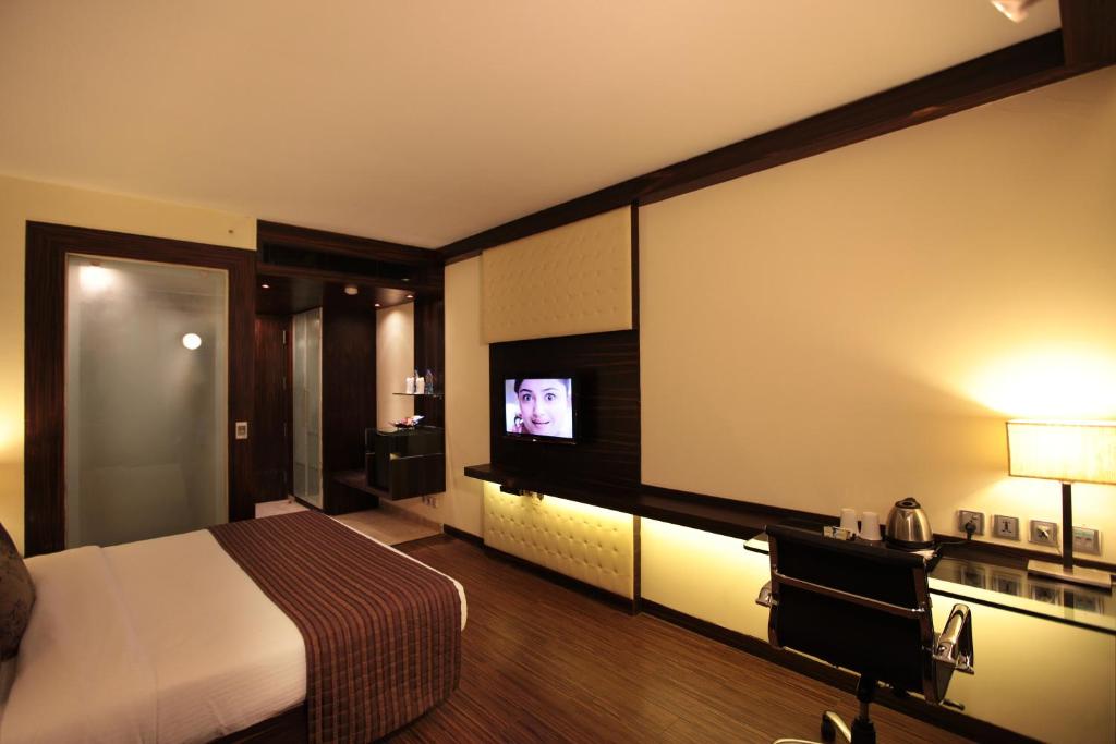 a hotel room with a bed and a flat screen tv at Hotel Private Affair (A Boutique Hotel) in New Delhi