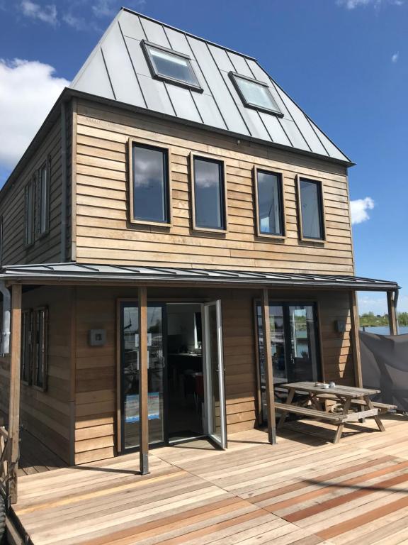 een huis met een gambrel dak op een terras bij Kaap Hoorn Club Bed en Breakfast in Hoorn