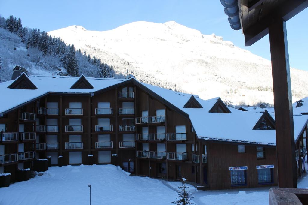 a lodge in the snow with a mountain in the background at L'Enclave in Les Contamines-Montjoie