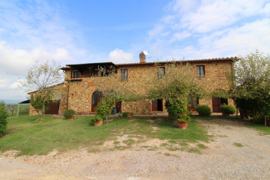 an old stone house with trees in front of it at Casa Bella in Torrita di Siena