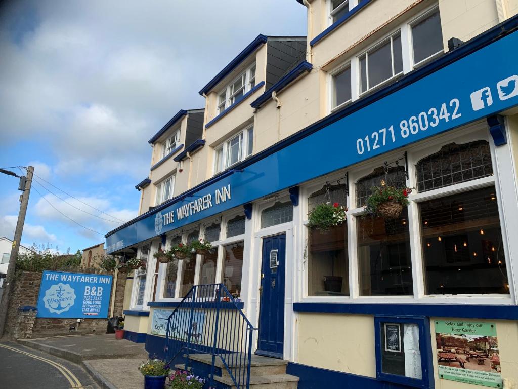 a building with a blue sign on a street at Wayfarer Inn in Instow