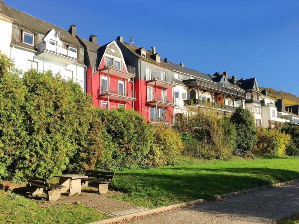 czerwony budynek z ławką przed nim w obiekcie Ferienhaus Mosellage w mieście Zell an der Mosel