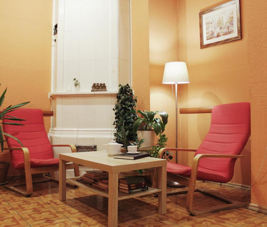 a waiting room with two red chairs and a table at "Репин" на Невском in Saint Petersburg