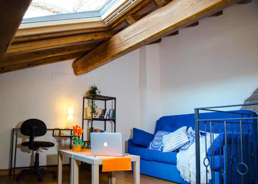 - un salon avec un canapé bleu et une table avec un ordinateur portable dans l'établissement Cuore del Borgo, à Sutri