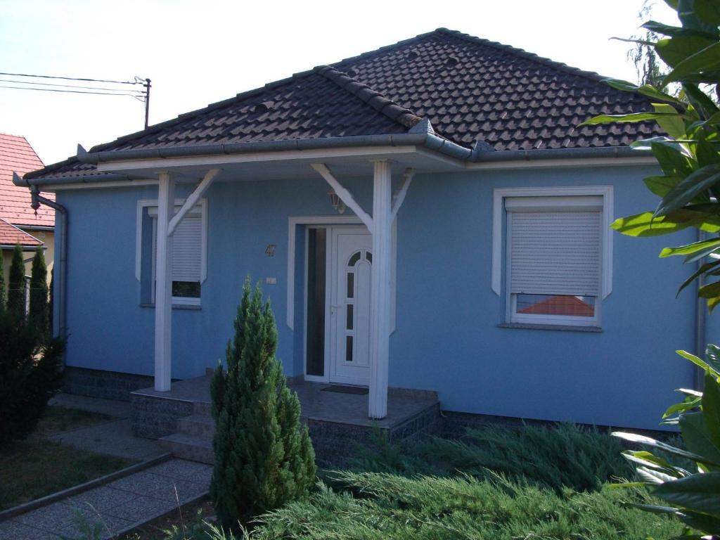 ein blaues Haus mit einem Fenster und einer Tür in der Unterkunft Márti Vendégház in Hegykő