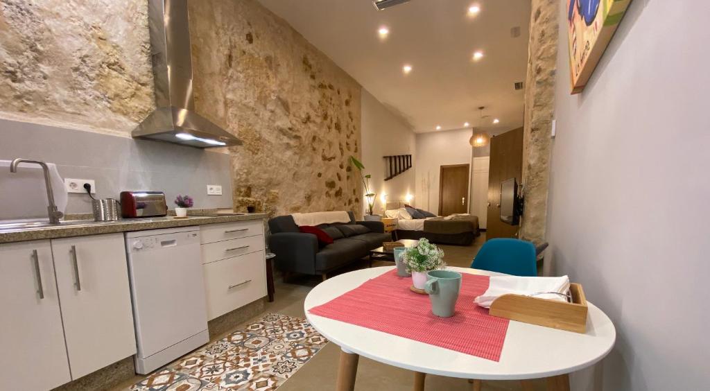 - une cuisine et un salon avec une table dans la chambre dans l'établissement GADEIRAS SUITES - Apartamentos Turísticos de 2 llaves, à Cadix