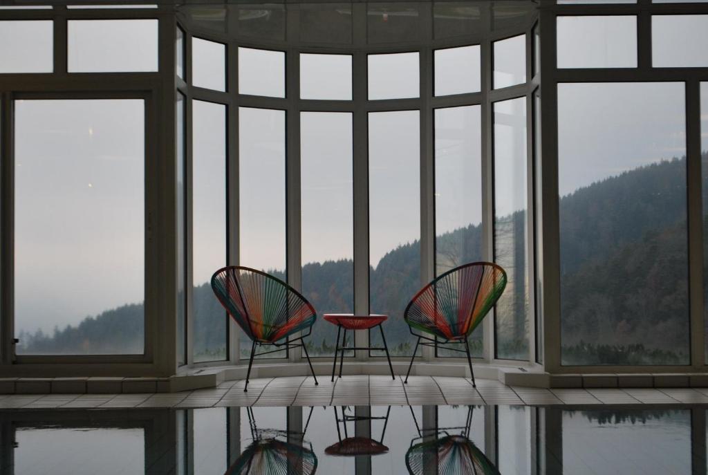 three chairs and a table in front of a window at Hôtel Panorama in Munster