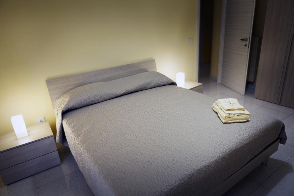 ein Bett in einem Schlafzimmer mit zwei Nachttischen und zwei Lampen in der Unterkunft La casa del ciliegio - appartamento a Caserta in Caserta