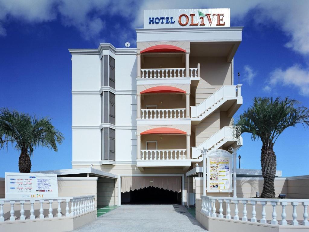 a white building with palm trees in front of it at Hotel Fine Olive Sakai in Sakai