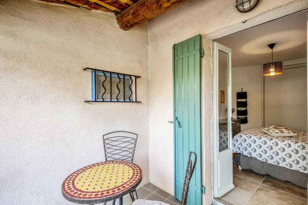a table and chair in a room with a bed at Maison de village in Bonnieux
