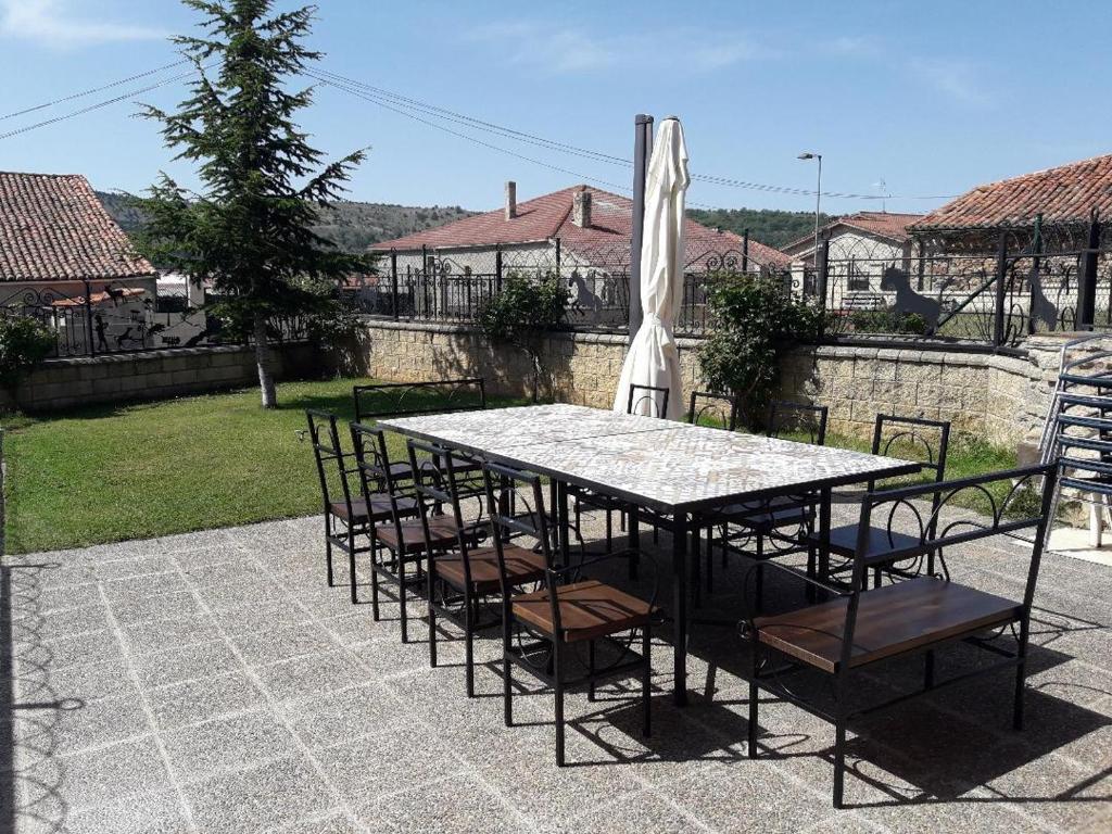 uma mesa com cadeiras e um guarda-sol num pátio em Casa Rural La Casa Nueva de Abejar em Abejar