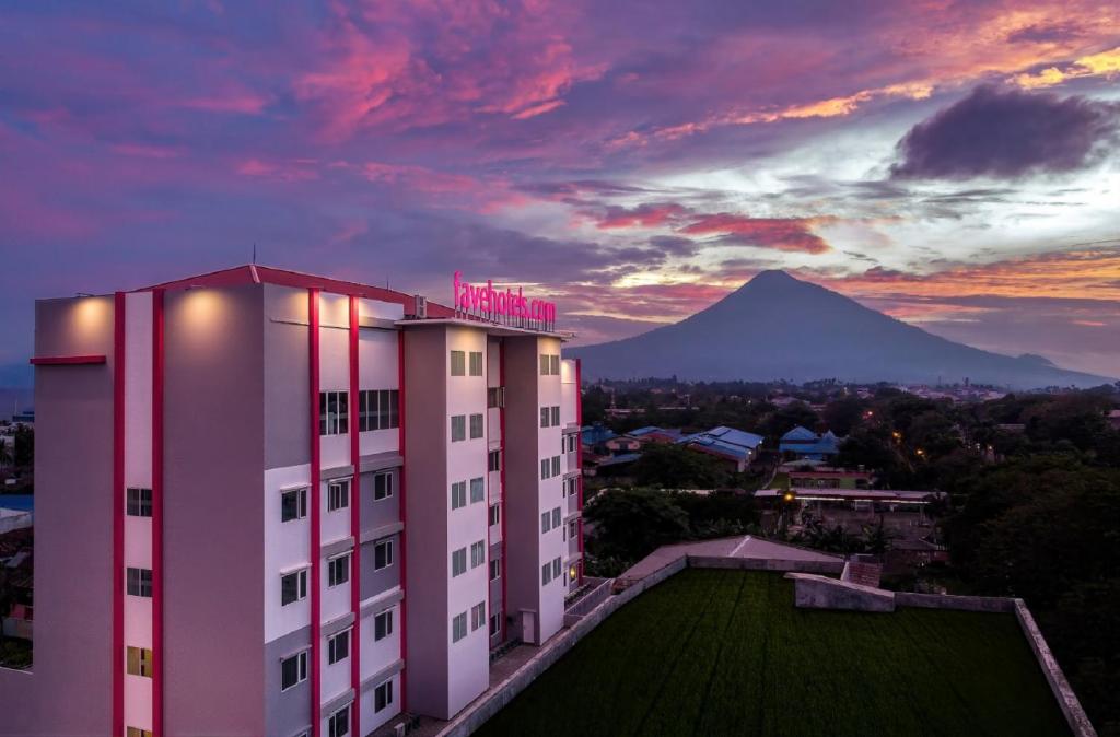 a hotel building with a mountain in the background at favehotel Bitung in Bitung