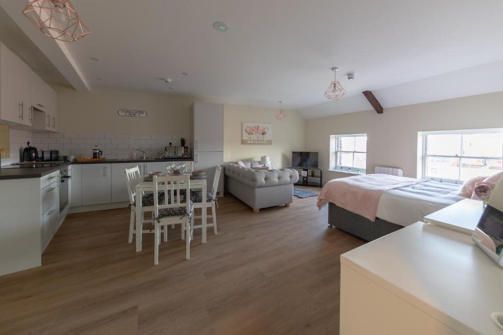 a bedroom with a bed and a kitchen and a living room at Hereford City Centre - Apartment 9, Isabella House - Modern Apartment In The Heart of The City - Sleeps 4 Guests - Hosted by RENTMYHOUSE in Hereford