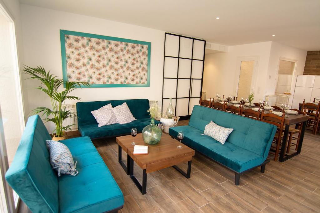 a living room with two blue couches and a table at Casa Rural Tía Sofia in El Toboso