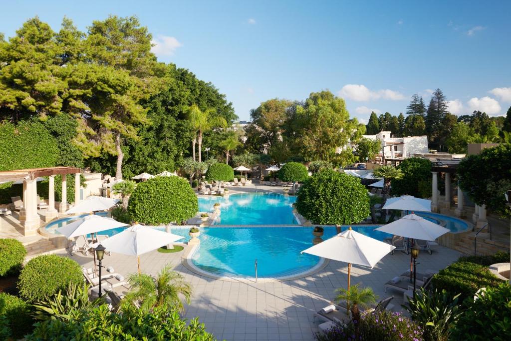 una vista aérea de una piscina con sombrillas en Corinthia Palace Malta en Attard