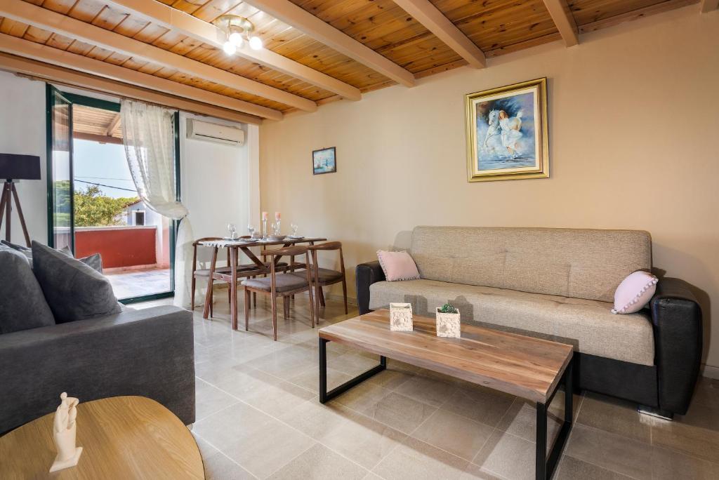 een woonkamer met een bank en een tafel bij Vasilikos Garden Suites in Vasilikos