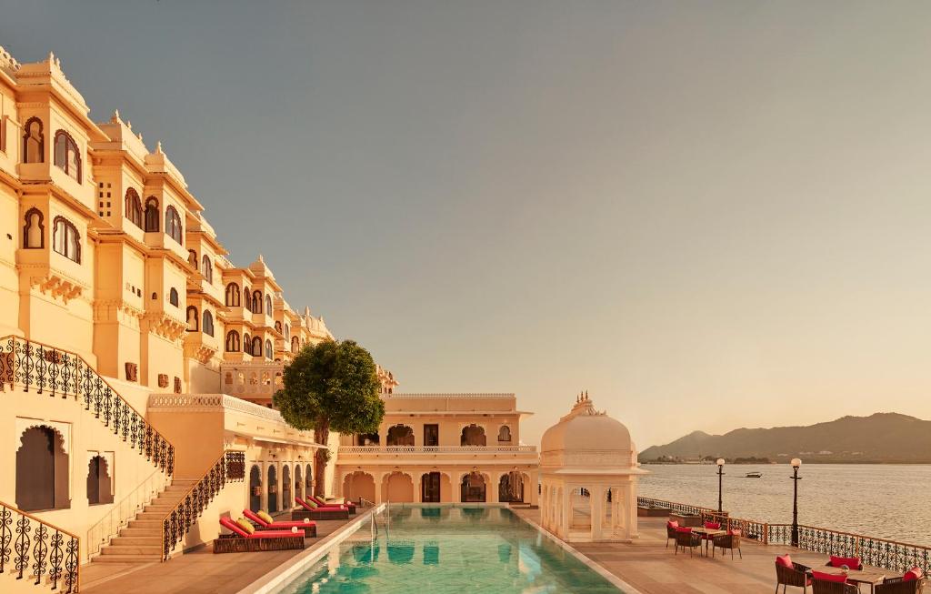 una piscina en un edificio junto a un cuerpo de agua en Taj Fateh Prakash Palace Udaipur en Udaipur