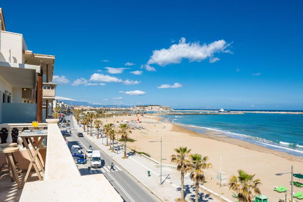 a view of a beach with palm trees and the ocean at Birais Beach Studios in Rethymno