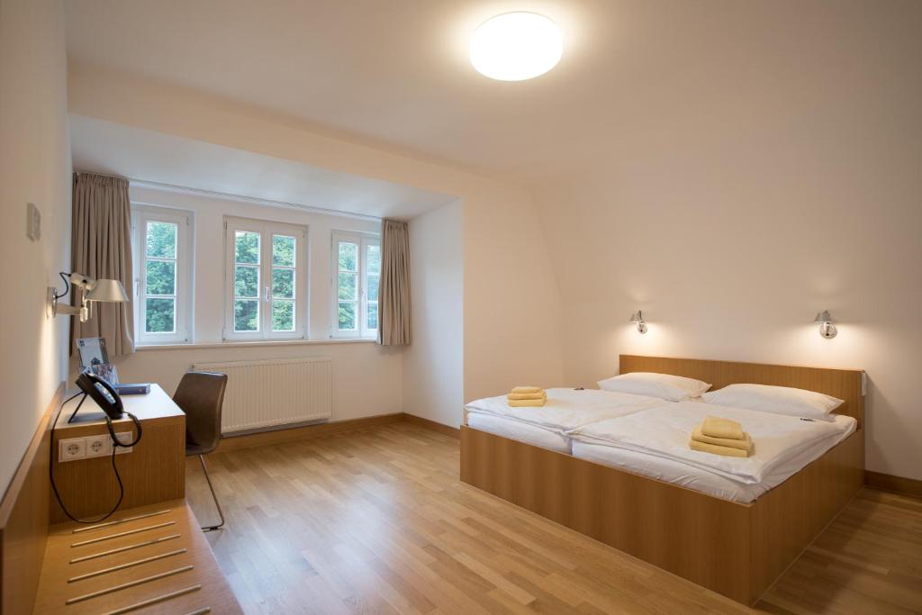 a bedroom with a large bed with yellow towels on it at Evangelische Tagungsstätte Hofgeismar in Hofgeismar
