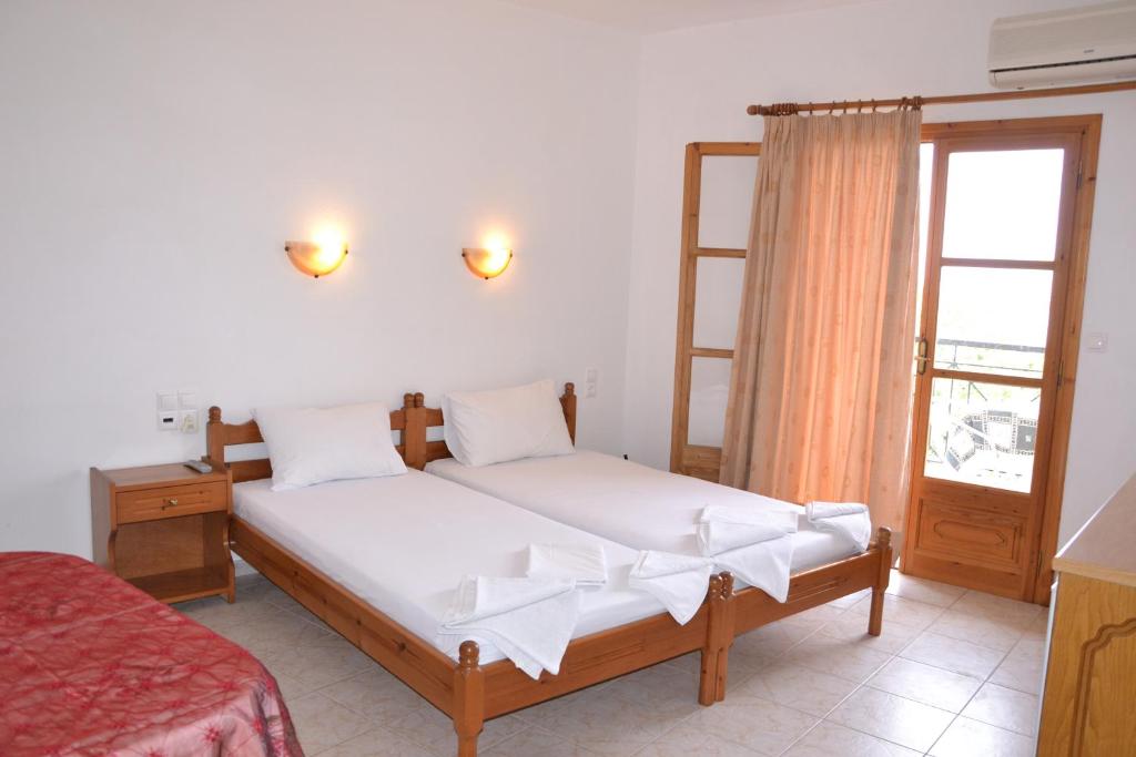 a bedroom with two beds and a window at skiathos studios HL in Skiathos